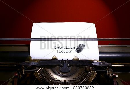 Typewriter Spelling Detective Fiction On Paper With Finger Print