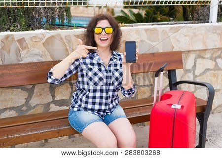 Technology, Emotions And People Concept - Happy Young Woman In Sunny Glasses Show Her Mobile Phone