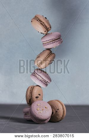 Sweet French Macaroons Stacked On Grey Concrete Background. Pastel Colored Balansed Macaroons. Pyram