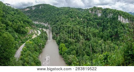 Skybridge Suspension Bridge Over A Gorge Over An Abyss With A River And Serpentine Road On A Cloudy 