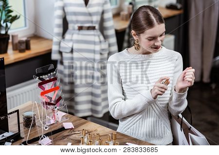 Long-haired Young Cute Lady In A White Sweater Choosing Perfume
