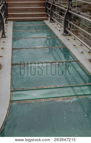 Glass Walkway Leading To Wooden Stairs Of Observation Platform In Public Park.