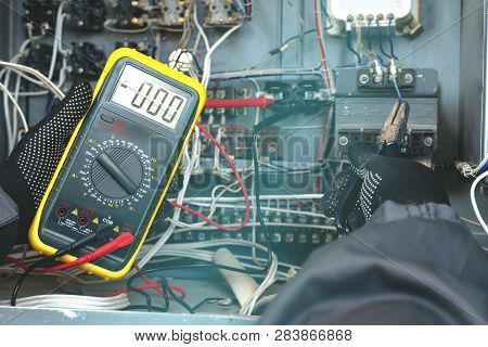 Electrician Is Checking The Voltage In The Electrical Circuit Of The Installation With A Multimeter.