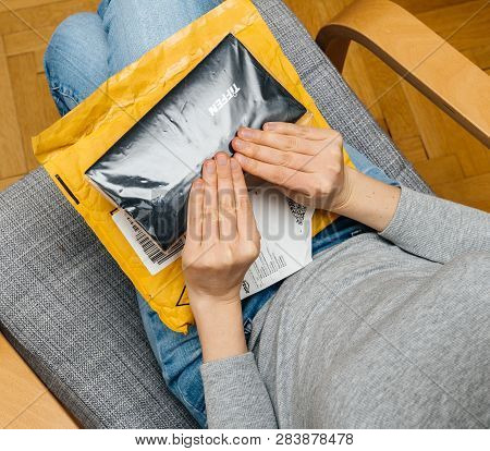 Paris, France - Nov 4, 2017: Woman Unboxing On The Living Room Armchair The Amazon Prime Cardboard B