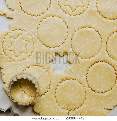 Raw cookies being cut with a star cookie cutter