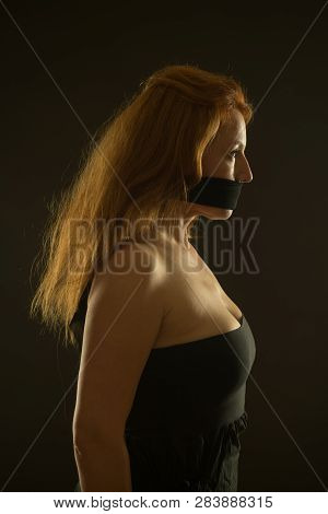 Prohibited. Profile Of Pretty Woman In Bare Shoulder Dress And Black Band Covering Her Mouth While L