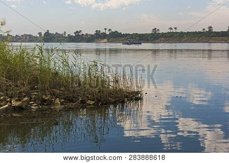 Panoramic Landscape Rural Countryside View Of Large River Nile With Grass Reeds In Foreground And Re