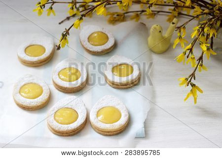 Homemade Easter Lemon Cookies And Forsythia Blooming Twigs On A Light Background.