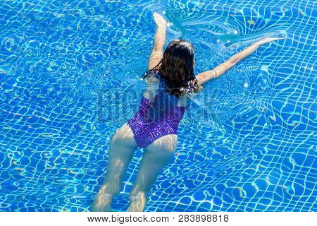 Top View Of Woman Swimming In A Pool. Straight Body, Slim Woman. Swim And Fitness Concept.
