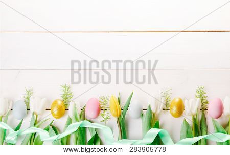 Easter Background With Easter Eggs And Spring Flowers. Top View With Copy Space