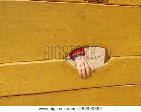 Children Hand With Small Fingers. Hand And Footholds On A Wooden Outdoor Climbing Wall.