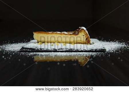 One Slice Of Cheesecake Covered With Powdered Sugar And Poured With Honey