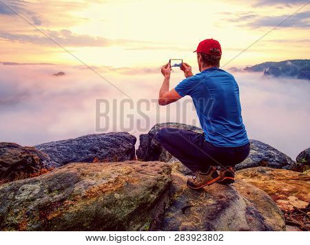 Hiker Takes Selfie Photo, Fall Nature Adventure. Man Sit On Stone On Mountain Sumit  Daybreak Horizo
