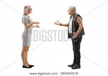 Full length profile shot of a young woman talking to an angry male punker in a leather vest isolated on white background