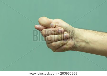 Male Hand On White Wall Background, Show A Fig
