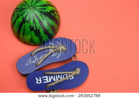 Decorative Wooden Flip Flops And Squishy Toy Watermelon  On A Coral Background Copy Space