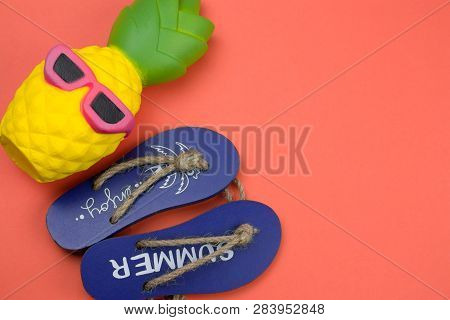 Top View Decorative Wooden Flip Flops And Squishy Toy Pineapple On A Coral Background Copy Space