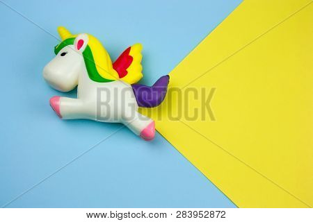 Top View Unicorn Squishy Toy On A Blue And Yellow Background