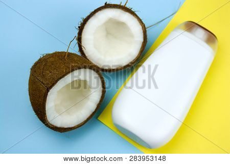 Flat Lay Coconut And Mock Upwhite  Plastic  Bottle  On A Yellow And Blue Background