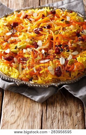Iranian Jeweled Rice With Dried Fruits, Carrots, Orange Zest And Nuts Closeup On A Plate. Vertical