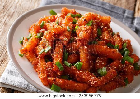Asian Honey Chilli Potato Wedges With Hot Sweet Sauce, Sesame And Green Onions Close-up. Horizontal