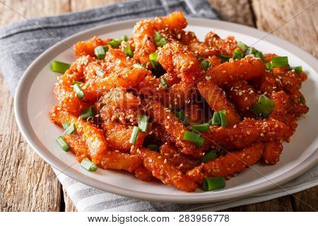 Sticky Honey Chilli Potatoes In A Spicy Sauce, Sesame Seeds And Green Onions Close-up On A Plate. Ho