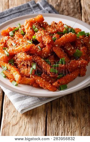 Delicious Honey Chilli Potatoes With Sesame And Green Onions Served On A Plate. Vertical