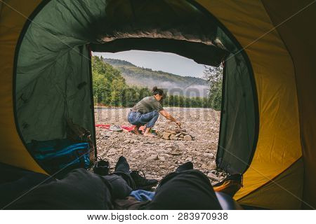 Couple Resting At Nature. Camping. Cooking On Campfire. View From Tent