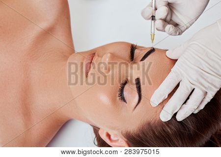 Closeup Of Beautiful Young Woman Getting Facial Beauty Injections. Plastic Surgery. Hands In Gloves 