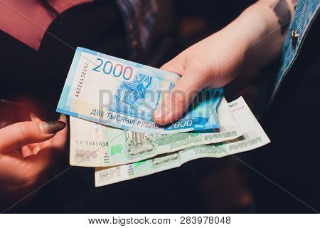 Russian Rubles In The Hand Of A Fan.male Hand Holding Many Of The Russian Banknotes.the Transfer Of 