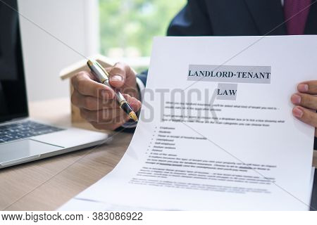 The Hand Of A Man Holding A House Purchase Contract With A Pen Showing Up To Customers. House Salesm