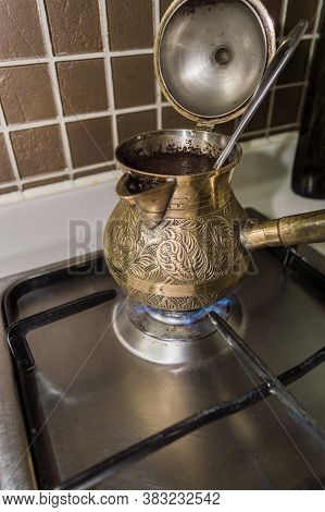 Brewing Fresh Coffee In Bronze Turkish Cezva On Gas Stove In The Morning