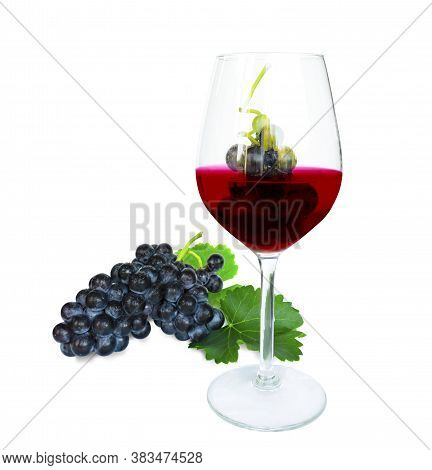 Grape Fruits In A Glass Of Dark Purplish Red Wine And Bunches Of Fresh Deep Black Berry Ripe Grapes 