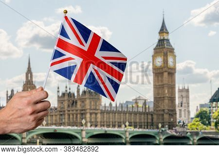 Toursist In London Holding Flag Of Great Britain In Hand. Big Ben In Background.