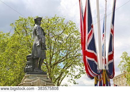 London, Great Britain -may 23, 2016: A Bronze Statue Of Captain James Cook By Thomas Brock With Flag