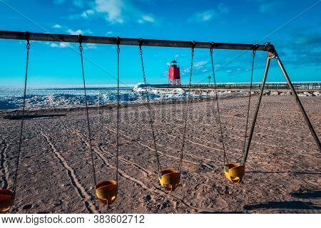Charlevoix, Mi /usa - March 2nd 2018:  A Shot Of Charlevoix Michigan Beach Through A Swingset