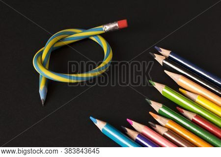Flexible Pencil And A Set Of Colored Pencils On A Dark Background. Selective Focus