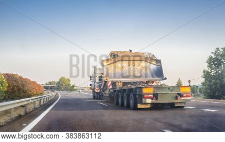 Oversize Load Truck Transporting A Huge Excavator Machine. View From The Inside Of The Car