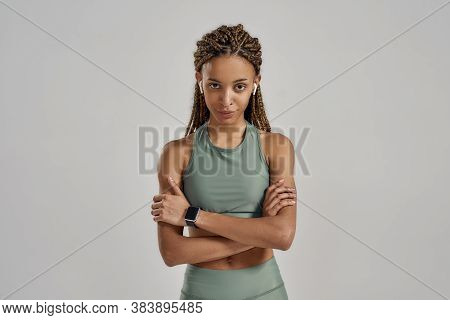 Sport And Fitness Concept. Young Confident Mixed Race Fitness Woman Wearing Wireless Earbuds Keeping