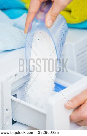 Washing Powder Detergent And Measuring Cup Pouring Into Machine. Household Duties, Clothes Laundry O