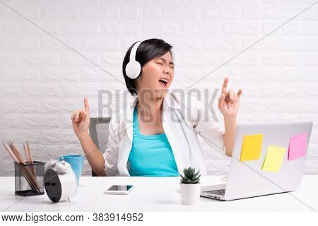Happy Woman With Headphones Listening Music At Office
