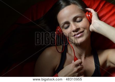 Красивая молодая женщина с красной Наушники