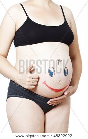 Malet glad smiley ansigt på maven af gravid kvinde 