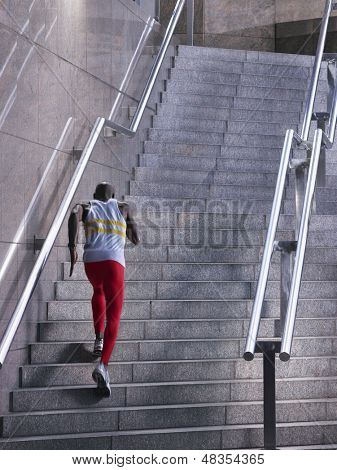 Vue arrière d'un athlète masculin exécutant escalier extérieur bâtiment