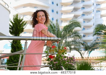 Mutlu genç kadın konut kompleksi balkonda durumda