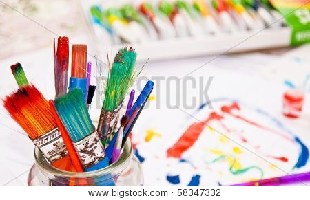 Colourful Paint Brushes with Paints in Background