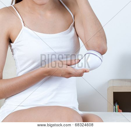 woman scrubbing her elbow with scrubber machine