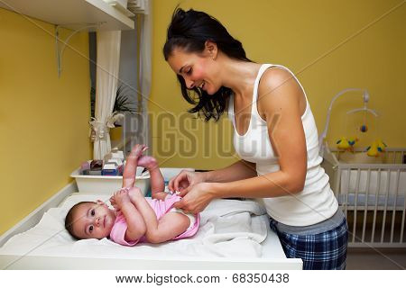 A Mother Changing Her Baby Nappy .