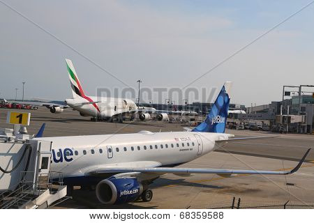 JetBlue Embraer 190 aircraft at the gate at the Terminal 5 and Emirates Airline Airbus A380 at JFK