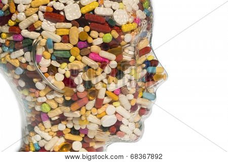 a head made of glass filled with many tablets. photo icon for drugs, abuse and addiction tablets.